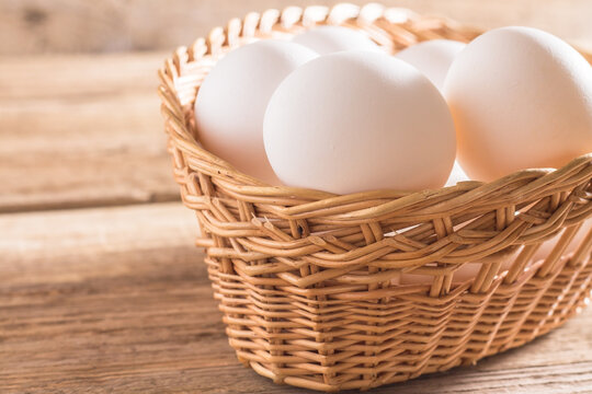 White eggs in bascet on wooden background