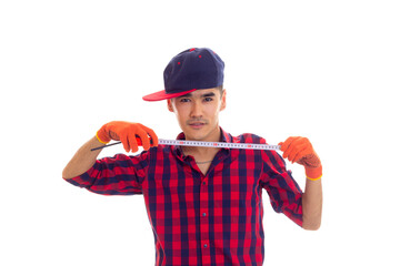 Young man in gloves and snapback holding tape-measure