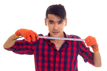 Young man in gloves holding tape-measure