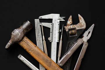Tools for repairing and renovation concept on black background top view. hammer pliers,...