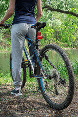 Relax on a mountain bike ride along the forest path. Sports and the concept of active life in the summer. Vertical frame