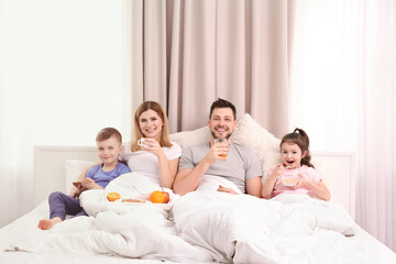 Obraz na płótnie Canvas Happy family having breakfast in bed