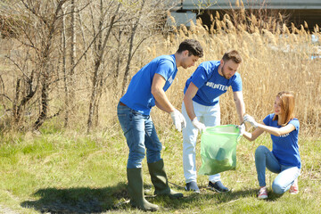 Young volunteers gathering garbage outdoors