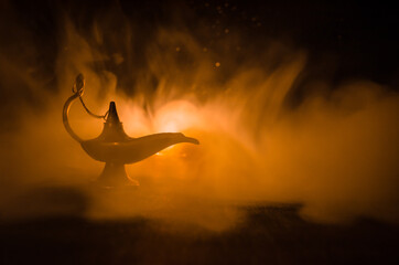 Antique arabian nights style oil lamp with soft light white smoke, Dark background. Lamp of wishes...