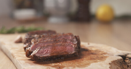 pouring meat juice on medium rib eye steak on board, wide photo