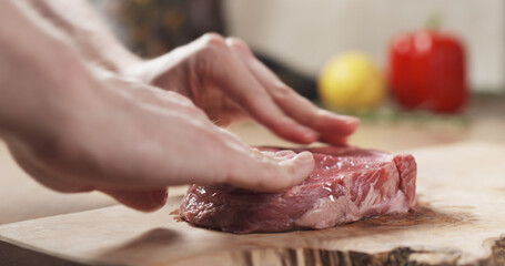 olive oil rub into raw rib eye steak on board, wide photo