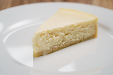 cheesecake on plate on wood table, shallow focus
