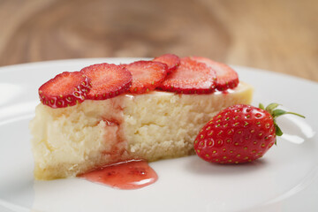 cheesecake with strawberry on plate closeup, shallow focus
