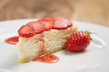 cheesecake with strawberry on plate closeup, shallow focus