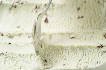 mint ice cream with chocolate chips scooped with spoon, shallow focus