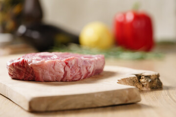raw rib eye steak on board closeup, shallow focus