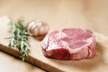 raw rib eye steak on board closeup, shallow focus