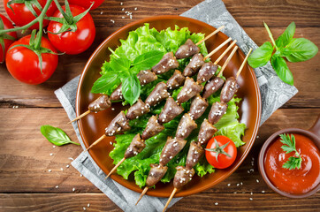 Chicken hearts on a barbecue sticks topped with sesame seeds
