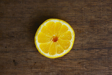 Isolated Yellow Fresh Lemon Slice Over Wooden Background