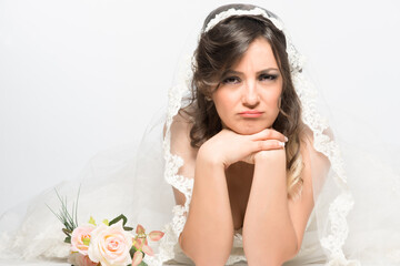 Sad and disappointed bride lying on the floor with rose flower
