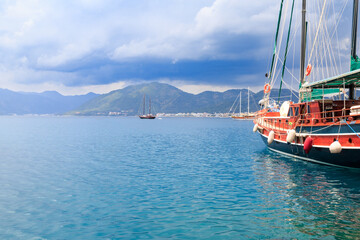 Boat in the seaport of Marmaris with mountains over clouds