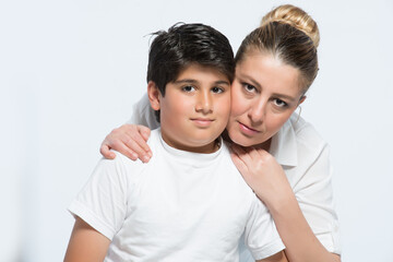 Mother and son posing while sitting both in white shirt