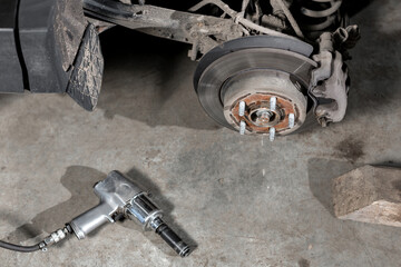 Closeup disc brake of the vehicle for repair. shot wheel, the tool for loosening the nuts. internal screw