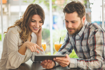 Young couple using tablet in a cafe