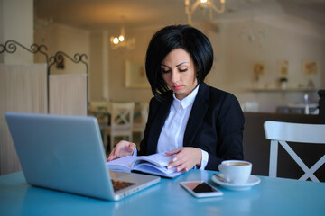 Fototapeta premium business lady dressed in black suit working on a laptop