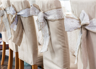 Festive wedding ceremony chairs decoration with bows of natural rustic style.
