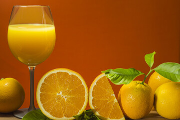 Orange juice in glass on orange background