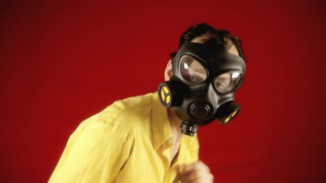 A man wearing a scary ugly gas is shocked by something and starts running for his life. Comic cartoonish scene.
