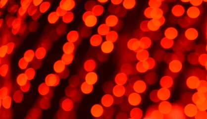 Defocused Bokeh twinkling lights background. Festive background with natural bokeh and bright red defocused lights.