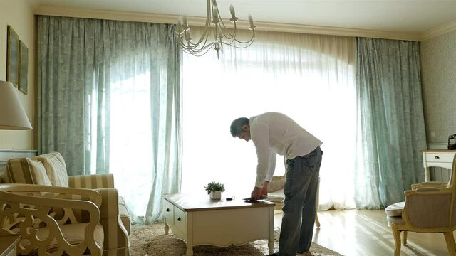 Man returning home reviewing household bills and packages on the table