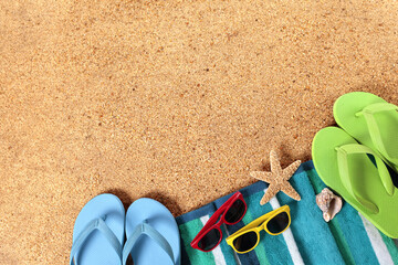 Beach background lower border with sunbathing towel flip flops  sunglasses and starfish on sand...