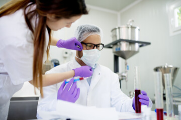 Nurse putting on a sterile mask on doctors face. Blood analysis laboratory.