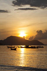 Beautiful sunrise seascape view with boat in phuket island.