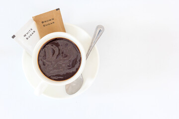 A cup of black coffee and sugar sachet for refreshing in the morning, Top view with copy space and text.
