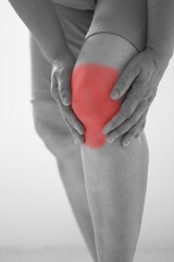 Soft focus of Old Asian women to knee injury on white background,black and white tone