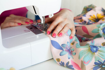 Young woman sewing while sitting at her working place