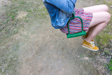 Detail of young caucasian person having fun on a swing