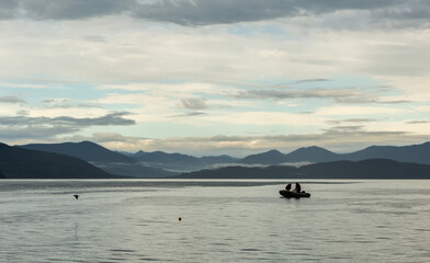 Obraz na płótnie Canvas Poachers on motor boat collect catch in Avacha Bay.