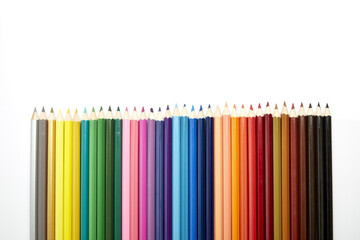 Many different colored pencils on white background