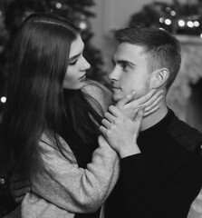 Young beautiful pretty woman with brown hair sitting at her husband or boyfriend knees and hugging...