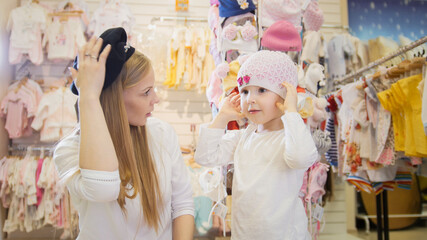 Mother and daughter trying on beautiful hats