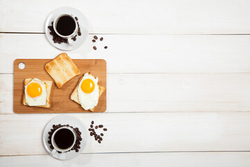 Fried eggs with toasts and coffee on the table