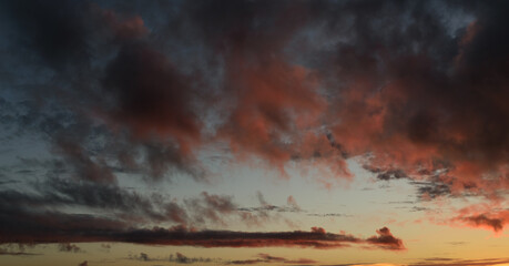 Dramatic sunset sky with orange colored clouds.