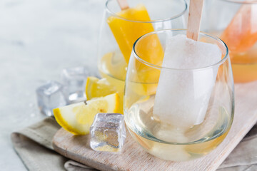 Colorful ice popsicles with wine in glasses