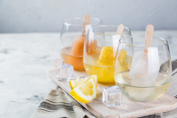 Colorful ice popsicles with wine in glasses
