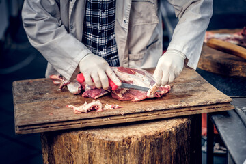 Bearded butcher cut fresh bacon meat.