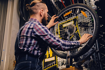 Fototapeta na wymiar Mechanic repairing bicycle wheel tire in a workshop.