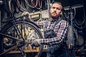 Mechanic doing bicycle wheel service manual in a workshop.