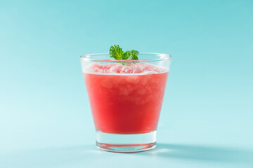 Glass of healthy watermelon juice in summertime on blue background.