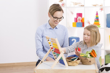 Tutor and girl counting with abacus