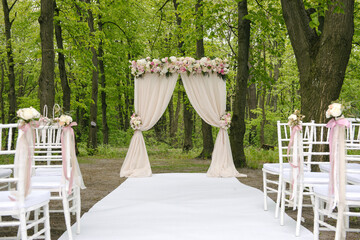 Adorable wedding archway with lined up chairs